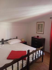 a bedroom with a bed with a red towel on it at Apartment House Aria in Baška Voda