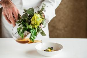 a chef holding a vase with a bowl of flowers at Carlton Hotel St Moritz - The Leading Hotels of the World in St. Moritz