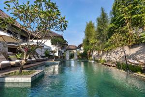 a swimming pool in the middle of a villa at Radha Phala Resort & Spa in Ubud