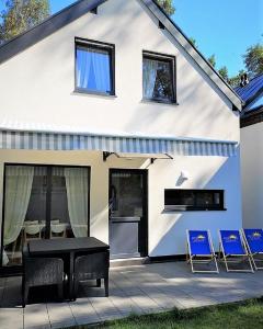 a house with a patio with chairs and a table at Przystanek Wczasy in Jastarnia