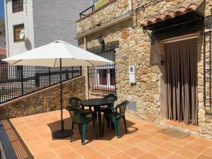 einen Tisch, Stühle und einen Regenschirm auf einer Terrasse in der Unterkunft Apartamento Rural Sierra de Segura in Segura de la Sierra