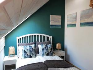 a bedroom with a white bed and a green wall at Przystanek Wczasy in Jastarnia