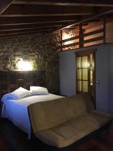 a white bed sitting in a room next to a window at Hotel Rural Las Nubes in Salas de los Infantes