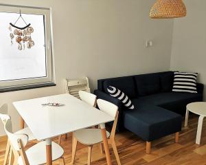 sala de estar con sofá negro y mesa en Przystanek Wczasy, en Jastarnia