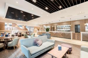 a lobby of a restaurant with chairs and tables at Edgbaston Park Hotel Birmingham in Birmingham