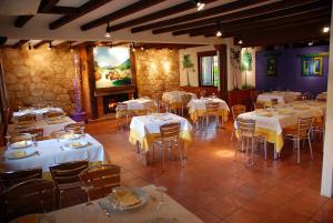 a dining room with tables and chairs with white table linen at Hostal El Cardenillo in Madrigal de la Vera