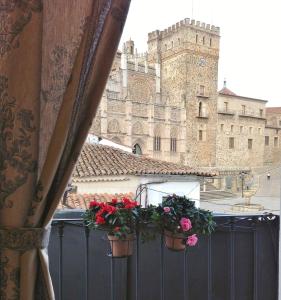 een uitzicht op een gebouw met bloemen op een hek bij Hostal Cerezo 2 in Guadalupe