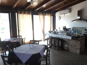 a room with two tables and a kitchen with windows at Ermes B&B in Falcone