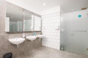 a bathroom with two sinks and a shower at Bobopod Dago, Bandung in Bandung +19 photos