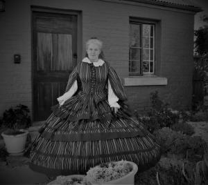 a woman in a dress standing in front of a house at Mulberry Cottage Unique B&B Accommodation in Richmond