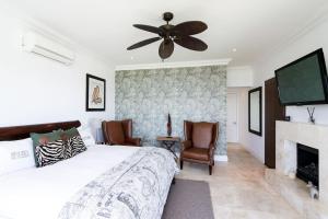 a bedroom with a bed and a ceiling fan at La Maison Hermes - Heated Saltwater Pool in Cape Town