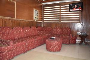 Una sala de estar con un sofá rojo y una mesa. en Hotel Islamabad Metro Inn, en Rawalpindi