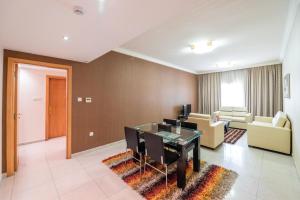 uma sala de estar com uma mesa de jantar e um sofá em Crystal Plaza Hotel em Sharjah