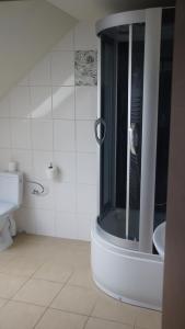 Un baño blanco con ducha y lavabo. en Agroturystyka Zapiecek, en Iłża 23 fotos más
