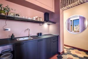 - une cuisine avec un évier et un miroir dans l'établissement CORNER211, à Rome