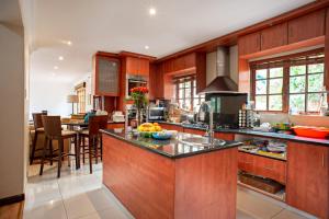 a kitchen with wooden cabinets and a counter top at Ekhaya Guest House in Ballito