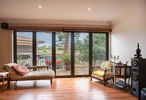 a living room with sliding glass doors with a balcony at Ekhaya Guest House in Ballito