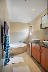 a large bathroom with a tub and two sinks at Ekhaya Guest House in Ballito