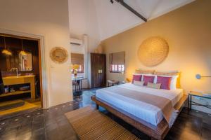 a bedroom with a large bed and a bathroom at Rambutan Resort &ndash; Siem Reap in Siem Reap