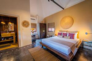 a bedroom with a large bed and a bathroom at Rambutan Resort – Siem Reap in Siem Reap