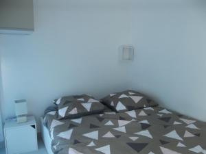 un letto con piumone nero e grigio in una stanza di P2 CABINE - LA GRANDE-MOTTE a La Grande-Motte