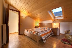 a bedroom with a bed and a window in a room at Pa' Eimbdlar in Sauris