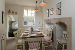 uma sala de jantar com uma mesa e cadeiras e uma lareira em The Paragon Townhouse em Bath