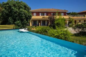 a swimming pool in front of a house at Hotel du Pont de l'Oso in Cala Rossa