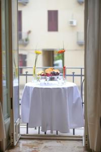 una mesa con un plato de comida y flores en ella en Soffio del Libeccio B&B, en Siracusa