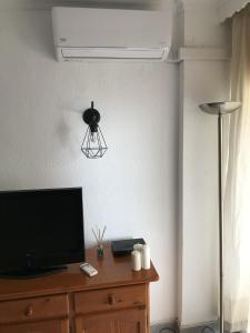 TV en un tocador de madera con lámpara en Beach Studio Benalmádena, en Benalmádena 12 fotos más