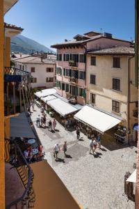 eine Aussicht auf eine Gruppe von Personen in einem Innenhof mit Gebäuden in der Unterkunft Albergo Aurora in Malcesine