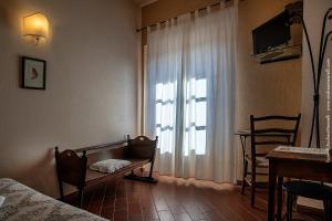 sypialnia z łóżkiem i oknem ze stołem w obiekcie Hotel Scilla w mieście Sovana