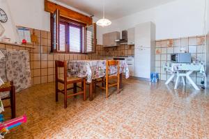 a kitchen with a table and chairs in a room at Casa vacanze Piscinas in Piscinas