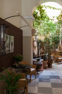 un patio esterno con tavoli, sedie e alberi di Xenon Apollonos a Ermoupoli