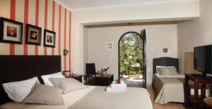 a bedroom with two beds and a tv and a window at Anthias Garden in Lefkada