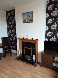 sala de estar con chimenea y TV en Haven en Herne Bay