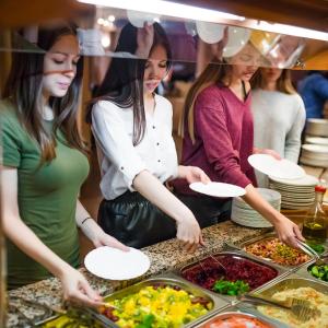 eine Gruppe von Frauen, die Essen am Buffet zubereiten in der Unterkunft Tourist Hotel in Omsk