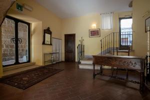 a living room with a staircase and a wooden table at Hotel Scilla in Sovana