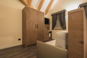 a bedroom with a bed and a wooden cabinet at X Alp Hotel in Pozza di Fassa
