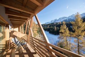 a balcony with a chair and a view of a river at Bike & Ski Hotel Diana in Nova Levante