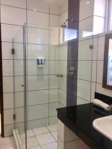 a bathroom with a glass shower and a sink at Bamburi Beach Studio Apartment B41 in Bamburi