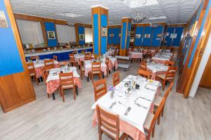 リオーロ・テルメにあるHotel Cristalloの青い壁のダイニングルーム(白いテーブル、椅子付)