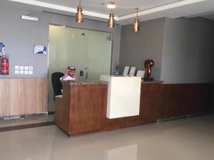 a woman sitting at a reception desk in a lobby at Arif Housing Units in Buraydah