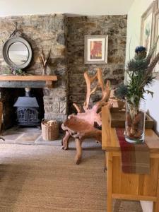 a large deer head in a living room with a table at Glencroft A Fairytale Highland Cottage in Aberfeldy