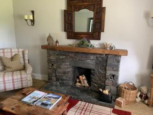 a living room with a fireplace and a mirror at Glencroft A Fairytale Highland Cottage in Aberfeldy