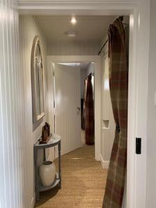 a hallway of a home with a table and a hallwayngth at Glencroft A Fairytale Highland Cottage in Aberfeldy