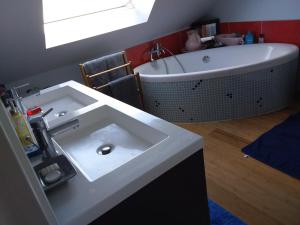 a bathroom with a white sink and a bath tub at Ker Kistin in Fouesnant