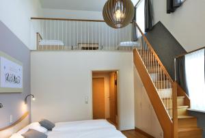 a bedroom with a bed and a staircase at JUFA Hotel Pöllau in Pöllau
