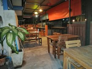 a restaurant with wooden tables and a potted plant at Chill land house in Bang Tao Beach