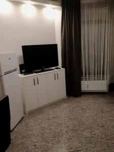 a living room with a flat screen tv on a cabinet at Apartma ROK in Ankaran